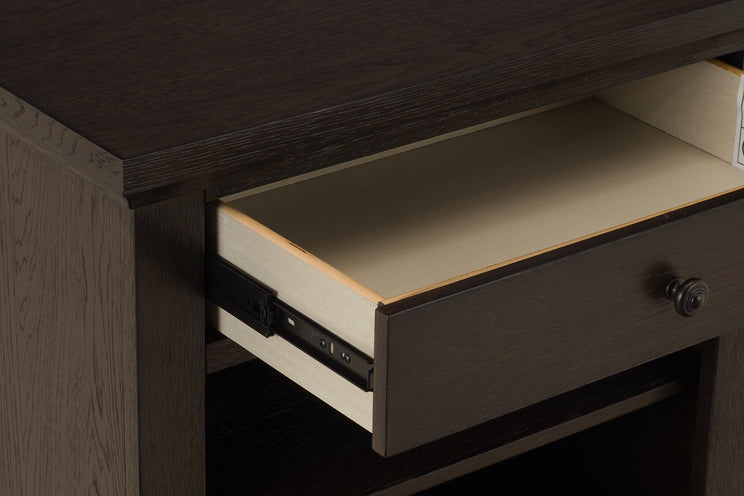 Close-up of a wooden desk with an open drawer.